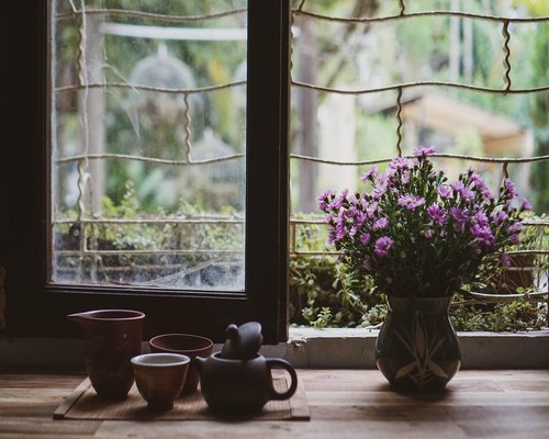person relaxing with a cup of tea by the window